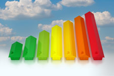 Image of seven houses in different colors and increasingly larger sizes made to look like a column chart on a backdrop of clouds.